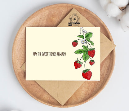 Strawberry loss greeting card on a wooden plate with kraft envelope