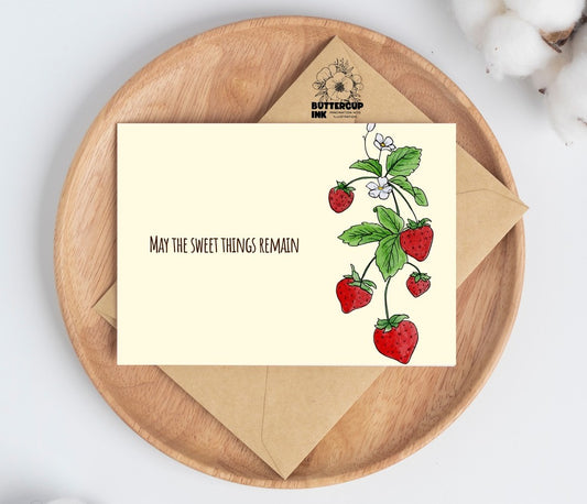 Strawberry loss greeting card on a wooden plate with kraft envelope